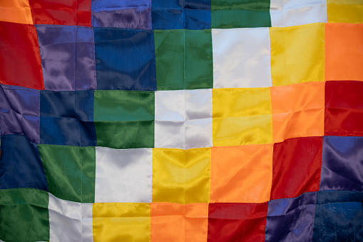 Close up image of a silk Wiphala Flag - a symbol commonly used to represent native peoples of the Andes.