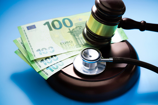 Stethoscope and judge gavel and 100 euro banknotes