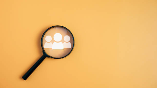 istock Customer group icons in a magnifying glass placed on a yellow background represent the selection of business goals, target customers. Marketing plans and strategies, customer-centric strategies. 1726130697