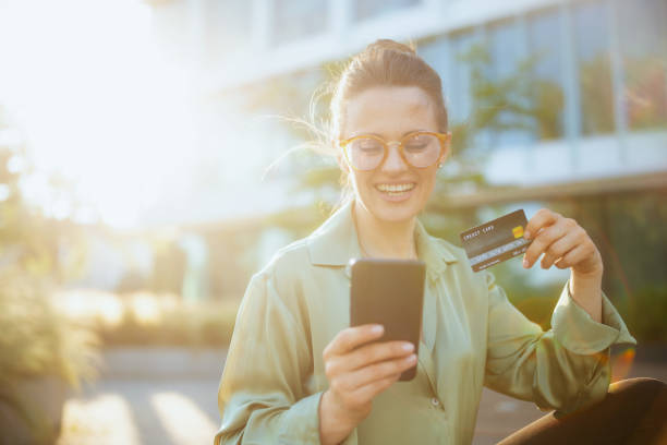 istock smiling woman worker in green blouse and eyeglasses using phone 1726144571