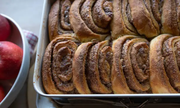 Delicious fresh baked danish pastry with caramelized cinnaman rolls. Served warm in a baking pan. Sweet autumn or winter food