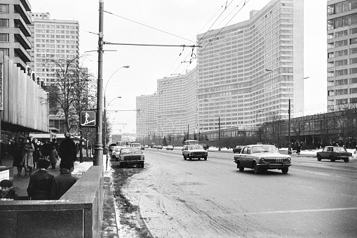 black and white street view in the 1950s with bus and one way sign