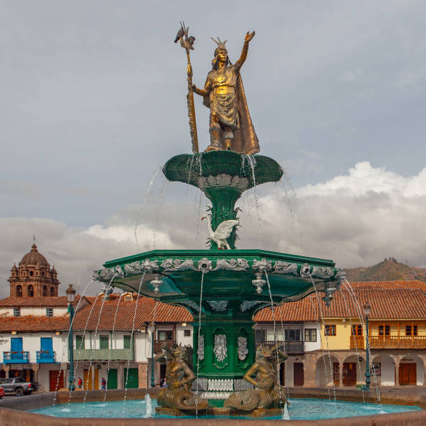 istock CUSCO, PERU - APRIL 30, 2022 : The statue dedicated to Inca emperor Manco Capac which sits above the water fountain at Plaza de Armas at Cusco in Peru. On left stands Church of the Society of Jesus. 1726175569