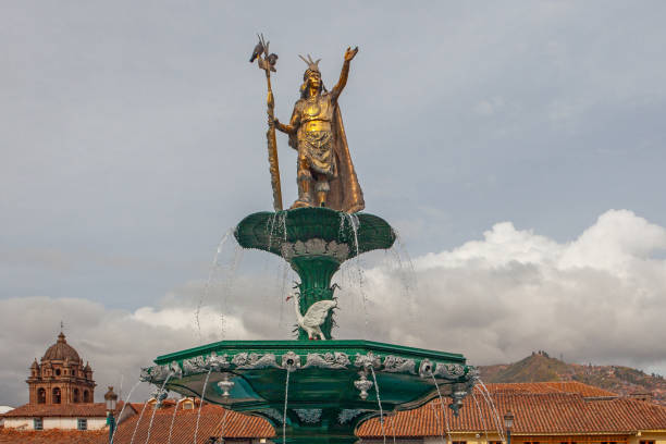 istock CUSCO, PERU - APRIL 30, 2022 : The statue dedicated to Inca emperor Manco Capac which sits above the water fountain at Plaza de Armas at Cusco in Peru. On left stands Church of the Society of Jesus. 1726176661