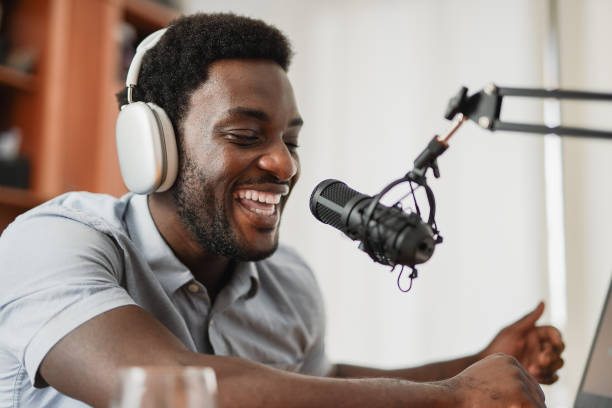 istock Young african man recording podcast inside office at home using headphones, microphone and laptop - Entertainment concept 1726177253