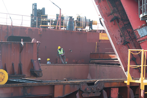 port salaya, gujarat, india -october 7, 2023 : port operators discharging cargo at ship by remote loader