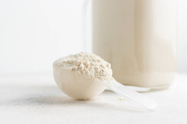 Whey protein powder in measuring spoon and glass jar of protein milkshake drink or smoothie on a white background. sport nutrition, bodybuilding food supplements Whey protein powder in measuring spoon and glass jar of protein milkshake drink or smoothie on a white background. sport nutrition, bodybuilding food supplements. lysine stock pictures, royalty-free photos & images