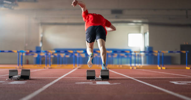 бегун, стоящий на стартовом блоке на трассе - hurdle hurdling track and field stadium exercise equipment стоковые фото и изображения