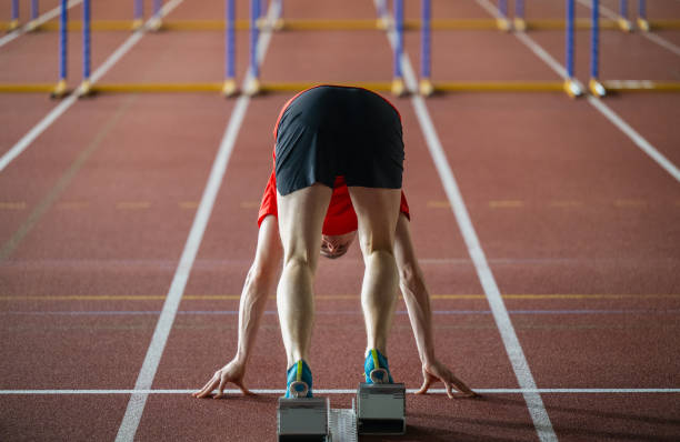 бегун, стоящий на стартовом блоке на трассе - hurdle hurdling track and field stadium exercise equipment стоковые фото и изображения