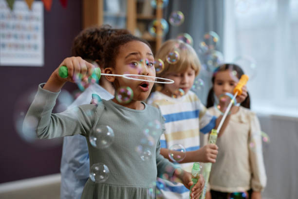 istock Little kids playing with soap bubbles in preschool 1726212157