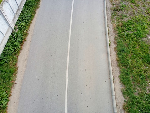 The road is paved with two-way traffic, top view during the day.