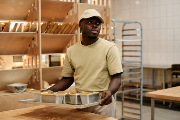 istock Young Black man holding tray with breads working in bakery 1726218633