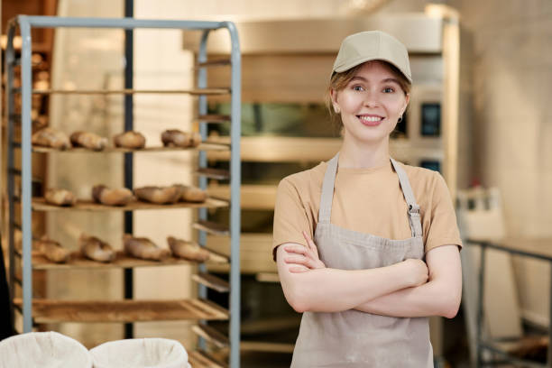istock Smiling young woman standing in bakery kitchen with arms crossed 1726218679