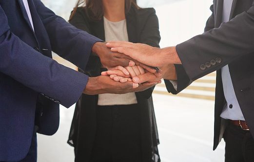 diverse business people stacked hands support together to startup mission or successful business
