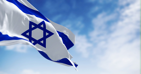 State of Israel national flag waving in the wind on a clear day. Blue Star of David in the center, flanked by two horizontal blue stripes on a white field. 3d illustration render. Selective focus