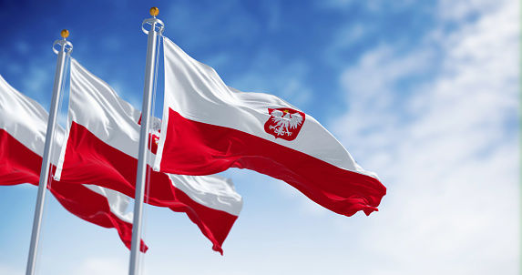 Three National flags of Poland waving in the wind on a clear day. Two horizontal white and red stripes with coat of arms. 3d illustration render. Rippling fabric. Selective focus