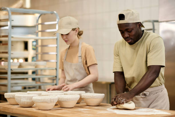 istock Two young people working in bakery and kneading dough for fresh bread 1726220973