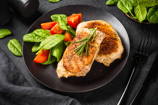 istock Meat steaks with fresh salad at black. 1726221569