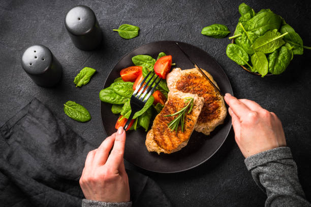 istock Meat steaks with fresh salad at black. 1726221578