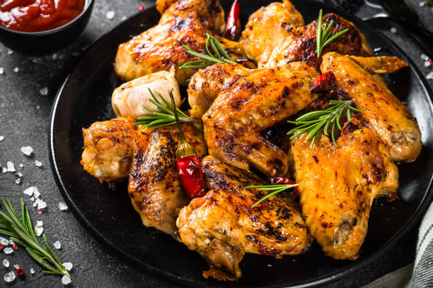 istock Grilled chicken wings with spices in black plate. 1726223871