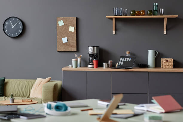 istock Cluttered office space in neutral grey with focus on coffee station 1726237327