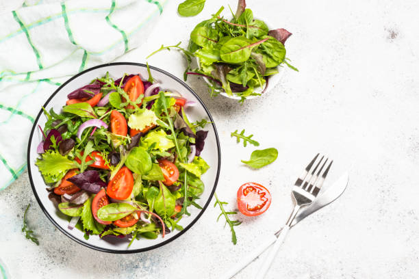 istock Green salad with fresh vegetables at white. 1726239056