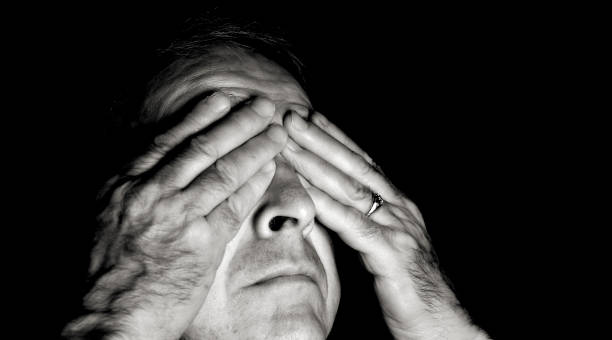 Hide Black and white portait of a man with his hands over his eyes..You can find more photographs of this model in visual sense stock pictures, royalty-free photos & images