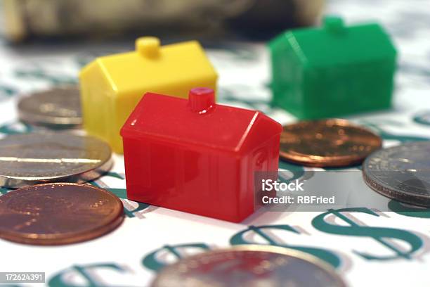 Monopoly Houses Surrounded By Coins Sitting On Dollar Signs Stock Photo - Download Image Now