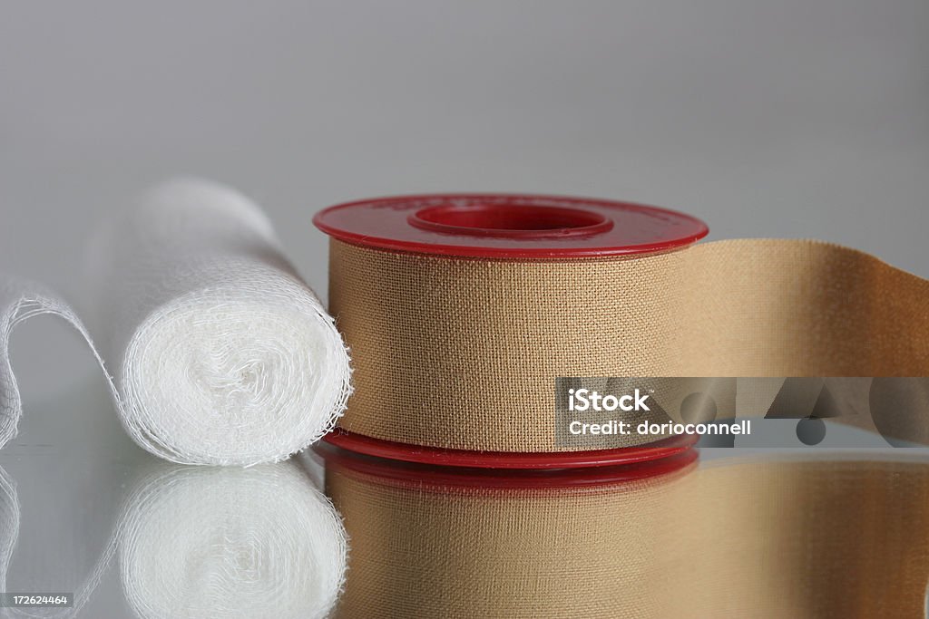 Roll of gauze and roll of Elastoplast tape first aid kit isolated over reflective surface Adhesive Bandage Stock Photo