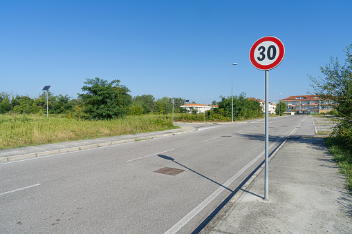 a sign indicating the 30 km/h limit on the side of a road