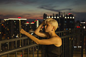 Blonde woman on the balcony. Night city background. Silhouette