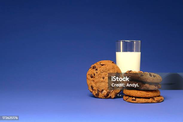 Leche Y Galletas Sobre Azul Foto de stock y más banco de imágenes de Azul - Azul, Galleta con trozos de chocolate, Al horno