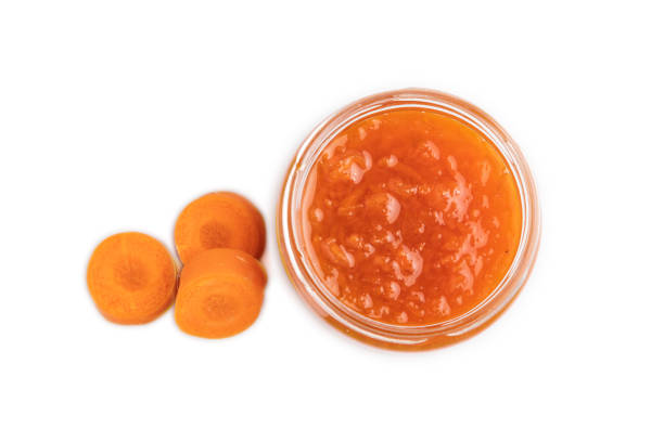 istock Carrot jam with cinnamon in glass jar isolated on white. Top view. 1726252291