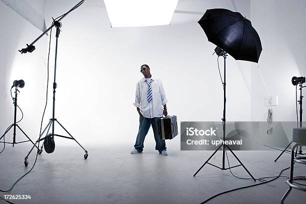A Man Standing With A Case In A White Studio With Lighting Stock Photo - Download Image Now