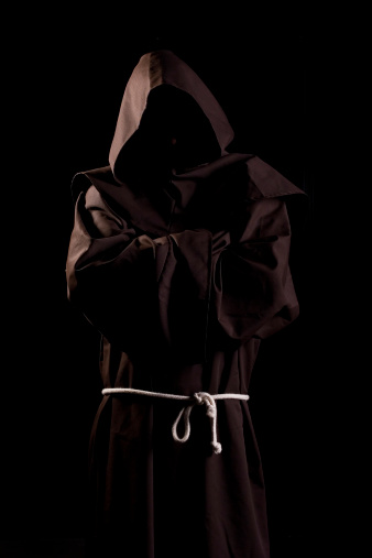 Monk in dark room. Cloak, rope, hood.