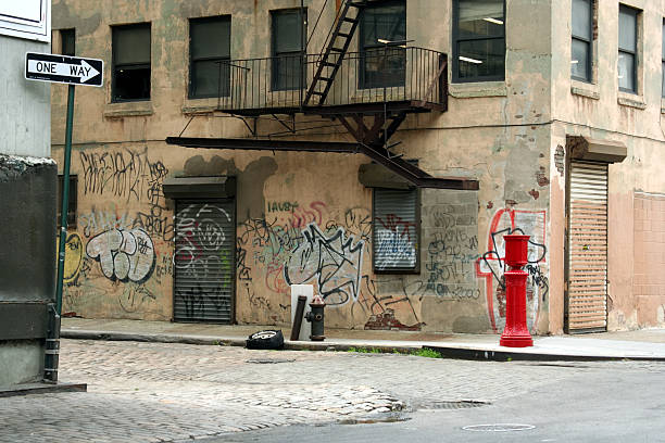 Deserted Brooklyn DUMBO Cobblestone Backstreet with Graffiti "Run down urban waterfront backstreet location in Brooklyn, New York City." dumbo new york photos stock pictures, royalty-free photos & images