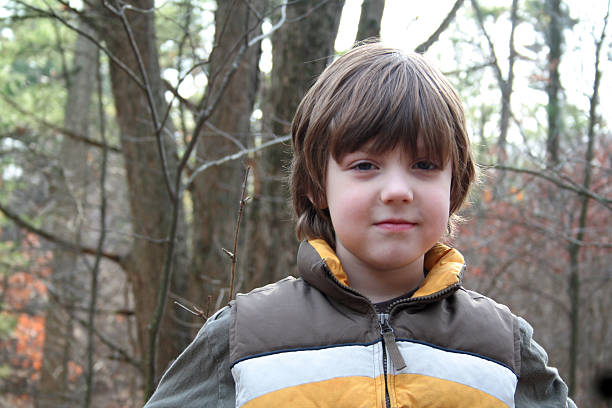 Young boy in woods stock photo