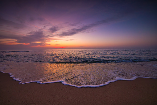 Beautiful cloudscape over the sea wave and beach shore, scenic sunrise ocean landscape.