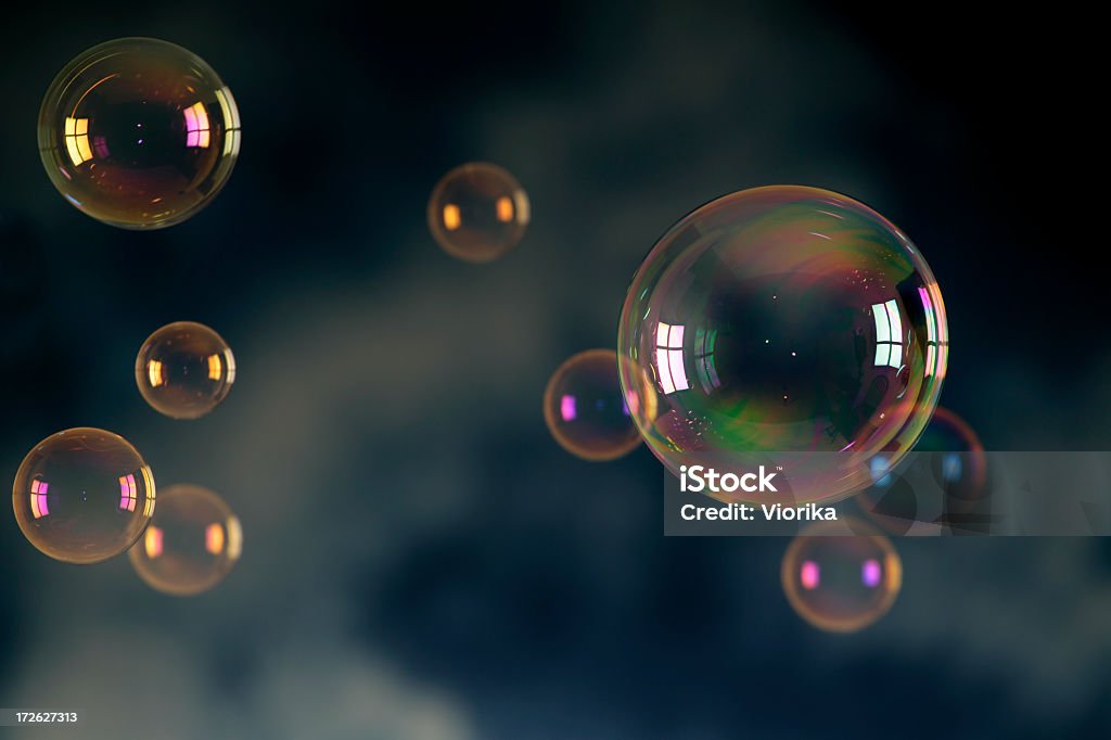 Soap bubbles floating in front of a dark background Soap bubbles on a blue background. Backgrounds Stock Photo