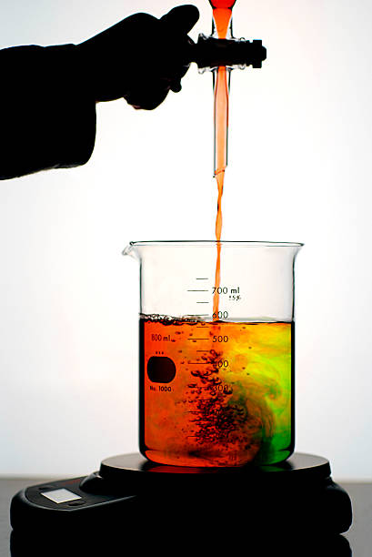 experimenter dodawanie płynu do zlewce z kolorowy wir - beaker laboratory weight scale physics zdjęcia i obrazy z banku zdjęć
