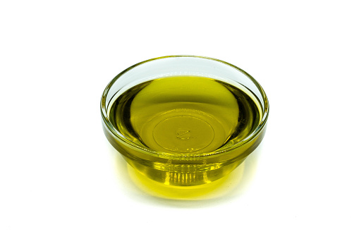 Olive oil in glass bowl isolated on white background