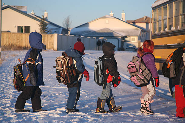 Children walk to the school bus on a winter day stock photo