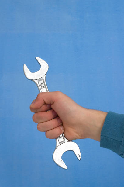 istock Wrench in hand, blue background 172628412