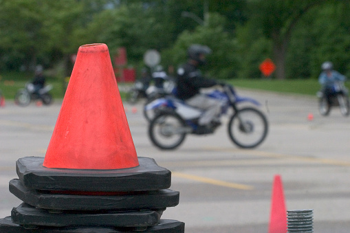 Pylons adorn the foreground at a motorcycle school.