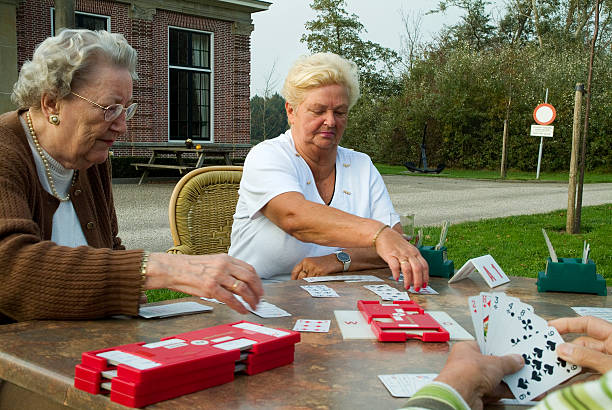 senior mujer jugando al bridge - bridge juego de cartas fotografías e imágenes de stock