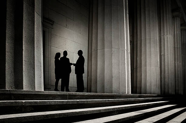 It's a Deal "Three people, silhouetted against a backdrop of power, shaking hands.To see more of my financial images click on the link below:" shade stock pictures, royalty-free photos & images