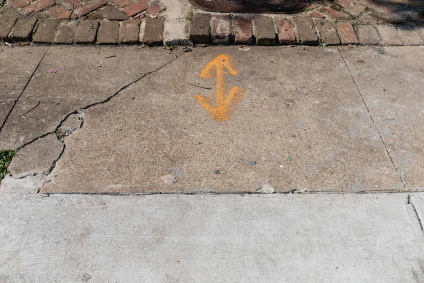 istock New and old concrete sidewalk section beside very old brick surface, spray paint arrows marking utilities, copy space, horizontal aspect 1726293482
