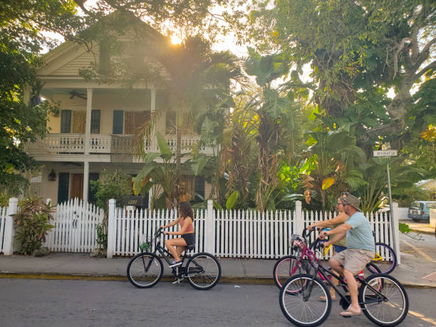 pessoas andando de bicicleta em key west florida - full length florida tropical climate residential structure - fotografias e filmes do acervo