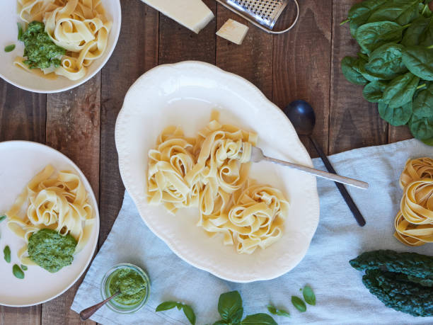 istock Tagliatelle pasta served at table with spinach and kale pesto beside parmesan cheese. Traditional Italian meal. 1726322142