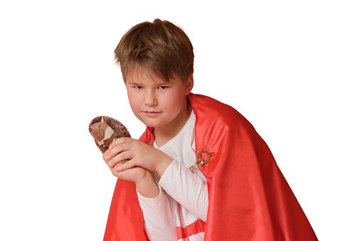 Little boy dressed like superhero holding a toy, isolated on white background